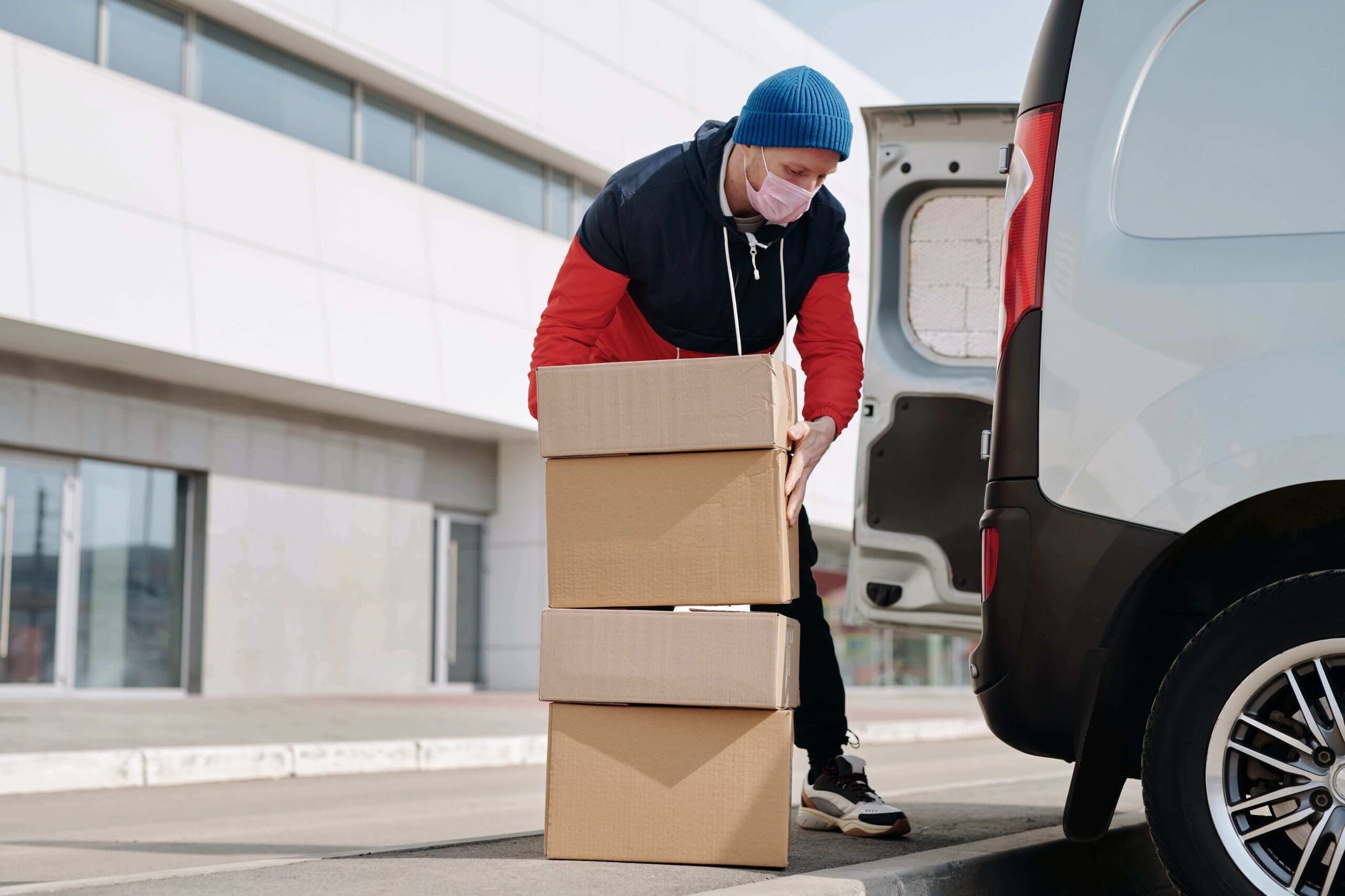 Na imagem, homem carregando caixas de papelão em carro. Conteúdo sobre direito do consumidor