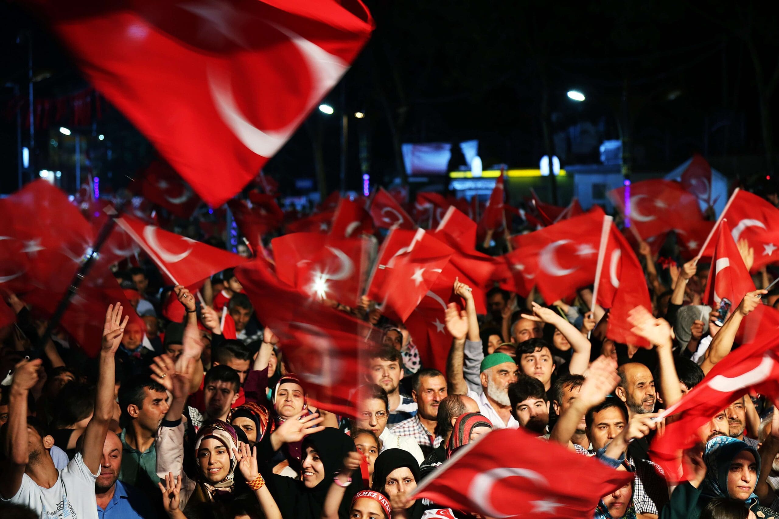 Na imagem, pessoas abanando bandeiras da Turquia.